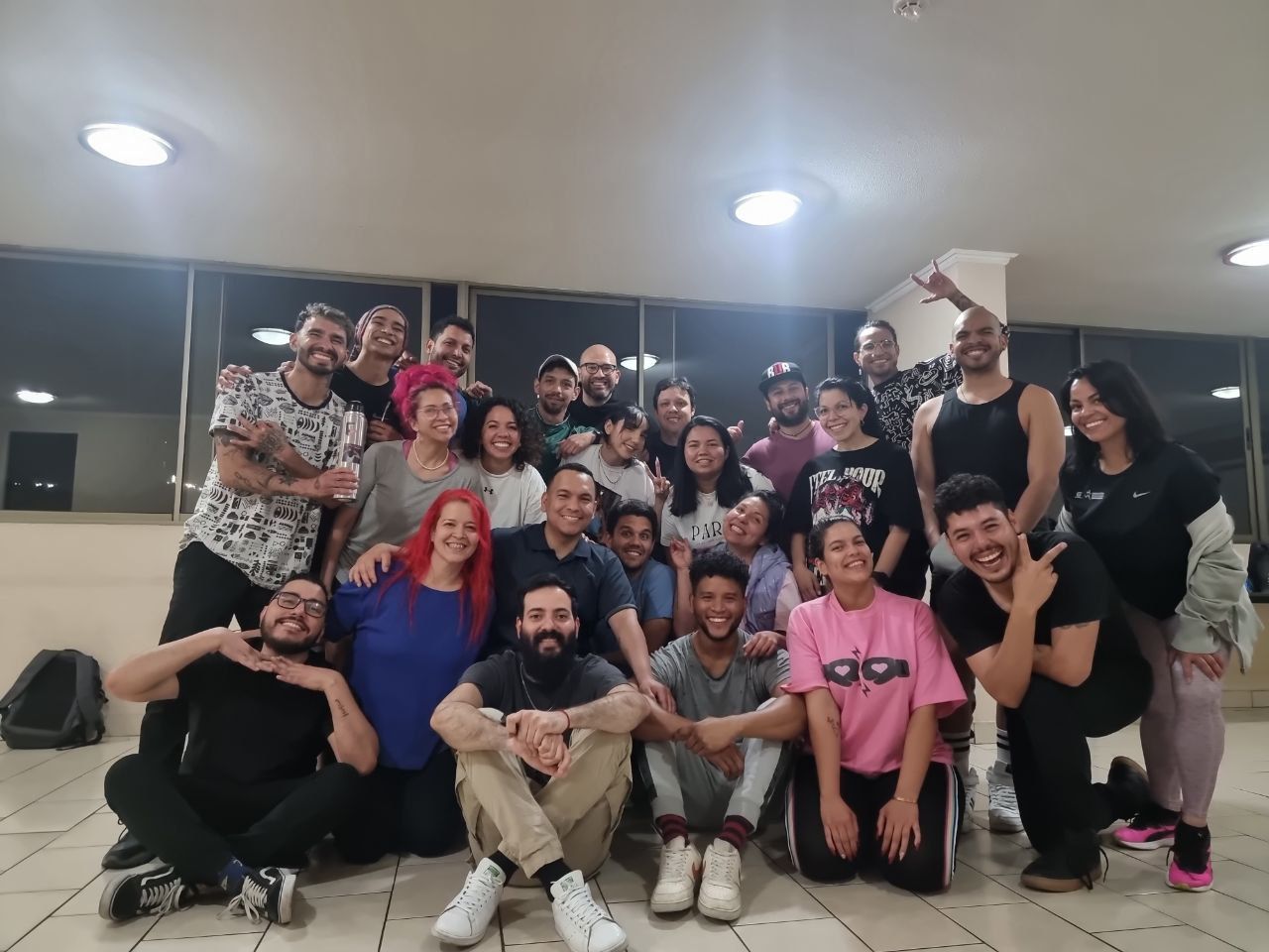 Grupo de alumnos de un taller de improvisación teatral posando juntos y riéndose al final de una clase